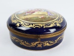 GRANDE CAIXA EM PORCELANA COM FUNDO NA TONALIDADE AZUL ROYAL. ARREMATE EM OURO. TAMPA TEM GRANDE RESERVA EMOLDURADA EM OURO COM CENA IDÍLICA. ASSINADA PELO ARTISTA AUBÈ. FRANÇA, SEC. XIX.21 CM DE DIAMETRO