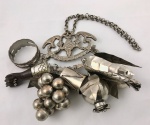 JÓIA DE CRIOULA  Bela penca de balangandans em prata de lei. Composta por suporte com sete balangandãs. 18 cm de altura (sem considerar o tamanho da corrente). 440 gNOTA: NOTA: Rompendo com regras sociais e até leis, mulheres negras que compraram sua alforria encontraram em adornos feitos em ouro e prata a forma mais direta de afirmar sua identidade. Só para se ter uma ideia da ousadia delas, no Brasil do período colonial, os negros eram proibidos de usar tecidos finos e joias. A venda de produtos diversos pelas ruas, principalmente alimentos, foi a forma que elas encontraram não só para comprar a liberdade como também para bancar a ostentação. Eram as chamadas escravas de ganho. Entre os elementos pendentes, em sua maioria também em prata, os mais frequentes são a figa, a chave, as moedas, o cilindro, a romã, o cacho de uvas, o peixe e os dentes de animais, remetendo a diferentes tradições. As jóias das crioulas confeccionadas nos séculos XVIII e XIX, consistem em uma coleção de peças de joalheria, especificamente para serem usadas por mulheres negras ou mestiças, na condição de escravas, alforriadas ou libertas. Estes adornos são hoje, objetos de museu, apresentados como exemplares de um tipo muito particular de joalheria, sempre associados às crenças religiosas de suas usuárias, ou vinculados aos senhores de escravos, como exemplo paradigmático de comportamento destes indivíduos, que adornavam suas escravas com uma quantidade exacerbada de jóias de ouro para exibir poder e riqueza. Os escravos de ganho saíam para trabalhar, em tempo parcial ou integral e deviam entregar ao senhor uma parte previamente acertada entre ambos do dinheiro que recebiam por dia ou por semana. Alguns desses cativos não moravam na casa do seu proprietário. Os exemplos mais marcantes desses escravos ganhadores são os mascates de ambos os sexos, os carregadores que trabalhavam em grupo, os artesãos e as quitandeiras Nas novas condições, a melhor estratégia era acumular em jóia, os valores, que um dia, seriam suficientes para a compra de sua alforria, de seus filhos, de parentes e amigos, ou seja, a compra da sua liberdade e também, a dos seus entes queridos. Ou ainda, participando da rede de solidariedade estabelecida pelos escravos, doando suas jóias para caixa de alforrias (fundos comuns para a libertação de escravos). Esta é a principal razão de se classificar estas peças como um design de resistência, por estes adornos de corpo significarem a sobrevivência ao sistema escravocrata. Assim, a joalheria escrava simboliza a resistência destas mulheres a condição de mercadoria. Usar jóias como acessório era imprescindível à elegância da mulher negra, sendo um fato tão pujante que vários viajantes de passagem pela Bahia foram uníssonos em apontar esta peculiar característica, impactante ao ponto de determinar uma portaria real no ano de 1636: El-Rei, tendo tomado conhecimento do luxo exagerado que as escravas do Estado do Brasil mostram no seu modo de vestir, e a fim de evitar este abuso e o mau exemplo que poderia seguir-se-lhe, Sua Majestade dignou-se decidir que elas não poderiam usar vestidos de seda nem de tecido de cambraia ou de holanda, com ou sem rendas, com ou sem rendas, nem enfeites de ouro e de prata sobre seus vestuários. Com este luxo, as escravas causam uma baixa de moral nas capitanias, pervertem os homens brancos, do que resulta o cruzamento das raças e o aumento sempre crescente do numero de pessoas de cor, o que de modo algum é conveniente (Jóia Escrava: design de resistência Slave Jewel: resistances design- Ana Beatriz Simon Factum)