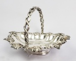 ELEGANTE CESTA EM PRATA DE LEI COM BORDA RELEVADA COM CAPRICHOSOS CACHOS DE UVA E FOLHAS DE PARRA EM RELEVO. ALÇA SIMULANDO TRONCOS DE PARRA. 28 CM DE COMPRIMENTO. 625 G