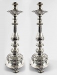 PORTENTOSO PAR DE TOCHEIROS EM PRATA DE LEI  COM FEITIO DE BALAÚTRE. DECORADO COM MAGNÍFICOS ROCAILLES RELEVADOS. SUSTENTADO POR TRÊS LINDOS PÉS EM GARRA. BRASIL, SEC. XIX/XX. 55 CM DE ALTURA, 6430 G (CONSIDERANDO CONTRAPESO DA BASE)