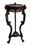 ELEGANTE COLUNA ORIENTAL EM MADEIRA EBANIZADA DECORADA A TODA VOLTA COM FENESTRAS. PERNAS RECORTADAS UNIDAS NA BASE POR MANDALA FENESTRADA. CHINA, SEC. XIX. 104 CM DE ALTURA 42 CM DE DIAMETRO