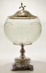 Pote para compotas em cristal incolor de formato esférico. Repousando sobre base em prata portuguesa e ornamentado por relevos fitomórficos. Séc. XX. 34 cm.