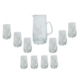 Conjunto para refresco em cristal liso, com base lapidada em formato diamante. Constando de: 1 jarra para refresco (22 x 16 x 11 cm) e 10 copos, sendo; 6 de 10 cm e 4 de 12 cm. Pertenceu ao Espólio de Vitória Dib Bachour.