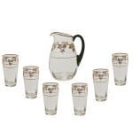 Conjunto para refresco em cristal apresentando friso dourado e decoração floral.  Constando de: 1 jarra para refresco (20 x 15 x 9 cm) e 6 copos (13 cm). 1 com bicado. Pertenceu ao Espólio de Vitória Dib Bachour.