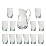 Conjunto para refresco em cristal europeu, translúcido e lapidado, apresentando decoração em folhagens. Constando de: Jarra para refresco (24 cm) e 12 copos (11,5 cm) sendo 1 com bicado. Pertenceu ao Espólio de Vitória Dib Bachour.