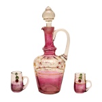 Conjunto em cristal na cor translucido e rosa, constando de licoreiro (23 cm) com dois copos (5 cm). Pertenceu ao Espólio de Vitória Dib Bachour.