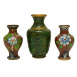 Conjunto de três peças chinesas de cloisonée, sendo um vaso na cor verde com frisos dourados (10,5 cm) e um par de vasos na cor vermelha com decoração floral no bojo (9 cm). Pertenceu ao Espólio de Vitória Dib Bachour.