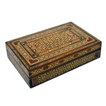 Caixa para joias marroquina em madeira nobre. Formato retangular com intensa decoração em marqueterie de madeiras claras e madrepérolas, predominando desenhos e forma geometrizadas. Interior forrado com veludo vermelho. 6 x 25,5 x 18 cm. Excelente estado de conservação. Pertenceu ao Espólio de Vitória Dib Bachour.