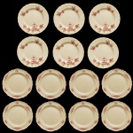 Conjunto de pratos de porcelana de porcelana inglesa. Borda ondulada e fundo de superfície bege com decoração de flores. Constando de: 8 pratos idênticos (20 cm). No fundo as inscrições: Woods Ivory Ware, England e 6 pratos idênticos (20 cm). Imperial Porcelana, Myott, Son & Co. England. (20 cm). Pertenceu ao Espólio de Vitória Dib Bachour.