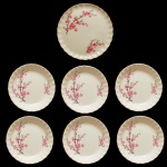 Conjunto para bolo de porcelana inglesa. Fundo de superfície bege com ramos de flores. Prato para o bolo (23,5 cm) e 6 pratos menores (4,5 x 19,5 cm). No fundo as inscrições: W. S. George. Pertenceu ao Espólio de Vitória Dib Bachour.