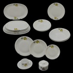 Serviço para jantar de porcelana nacional. Superfície de fundo branco, com decoração floral predominando na cor amarela. No fundo as inscrições: Porcelana Renner - Porto Alegre. Constando de 53 peças, sendo: 10 pratos rasos (25 cm); 10 pratos fundos (22 cm); 14 pratos p/ sobremesa (17,5 cm), 2 travessas redondas (27 cm), 2 travessas redondas (24 cm), 1 prato para arroz (29 cm), 2 travessas retangulares (39 cm e 36 cm), 2 travessas retangulares (33 cm), 2 travessas retangulares (30 cm), 1 açucareiro (8 x 10 cm), 7 xícaras c/ pires p/ chá ((5 x 10 cm / 15,5 cm pires). Uma fábrica de porcelanas guarda muitas semelhanças com a cozinha. As temperaturas altas. O trabalho árduo e meticuloso. O controle implacável da qualidade. Um lugar onde transformações intensas também acontecem. E a rigidez da matéria-prima bruta refina-se em algo tão único quanto a mais deliciosa receita: a porcelana. Pertenceu ao Espólio de Vitória Dib Bachour.