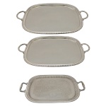 Conjunto de três bandejas com alças de formato retangular em metal espessurado a prata. Marcado no fundo Sophil. Made in Brazil. 62 cm (2) e 51 cm. Pertenceu ao Espólio de Vitória Dib Bachour.