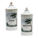 Par de potes de farmácia em porcelana da manufatura francesa. Superfície branca apresentando rótulos com as inscrições Salol e Rheum- Rha. França. Séc. XX. 27 cm.