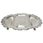 Travessa para Carnes (assados) com divisões, em metal espessurado a prata. Formato oval, borda onduladas e pés recurvos. No fundo as inscrições: Vintage Webster Wilcox International Silver Co. 54 x 38 cm.