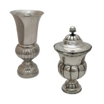 Conjunto de duas peças de metal prateado, sendo: A) Vaso apresentando parte superior lisa e gomado na parte inferior. B) Pote com tampa apresentando parte inferior com gomados. Base circular.