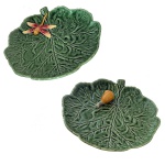 BORDALLO PINHEIRO RAPHAEL (Lisboa, 1846 1905) - Conjunto de dois covilhetes em cerâmica policromada, na forma de folhas e de cor verde. Bordas encimadas em relevo por libélula e caracol. No fundo as inscrições: Bordallo Pinheiro. Made in Portugal. 29 cm. Artista português que pintou lindos azulejos com influências Art Nouveau. Sua obra vem sendo transmitida há gerações na faiança artística, técnicas e procedimentos, alguns centenários, são responsáveis pela qualidade final. Artista português, desenhador, aguarelista, ilustrador, decorador, caricaturista político e social, jornalista, ceramista e professor.