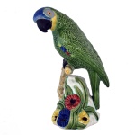 BORDALLO PINHEIRO, RAPHAEL (Lisboa, 1846 1905) - Estatueta em cerâmica policromada, representando papagaio pousado em tronco com flores. Decoração nas cores verde, azul, branco e amarelo. Feito à mão. No fundo as inscrições: Bordallo Pinheiro. Made in Portugal. 27 cm. Bordallo Pinheiro artista português que pintou lindos azulejos com influências Art Nouveau. Sua obra vem sendo transmitida há gerações na faiança artística, técnicas e procedimentos, alguns centenários, são responsáveis pela qualidade final. Artista português, desenhador, aguarelista, ilustrador, decorador, caricaturista político e social, jornalista, ceramista e professor.