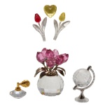 SWAROVSKI  Conjunto de seis peças comemorativas e miniaturas em cristal austríaco translúcido e lapidado. Constando de duas flores; 1 coração amarelo, 1 vaso com flores, 1 globo e perfumeiro. 5 cm (maior) e 2 cm (menor). Swarovski é o nome do cristal mais conhecido no mundo da moda por sua delicadeza, precisão e brilho. A companhia austríaca Swarovski AG, foi fundada por Daniel Swarovski que inventou uma máquina de corte automática em 1892.  Desde a sua fundação até os dias atuais, a marca foi fazendo fama na medida em que os cristais Swarovski foram se popularizando.