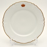 RAINHA DONA AMÉLIA (1865 1951) - Prato em porcelana da manufatura de Limoges. Borda recortada com friso em ouro e reserva contendo coroa real. Pertenceu ao serviço da Rainha Dona Amélia de Portugal. Esse serviço está exposto no Museu do Palácio Real da Pena em Sintra. França. Sec. XIX. 24 cm.