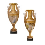 Par de vasos de porcelana francesa, decorado por reservas com figuras femininas. Corpo com intenso trabalho em ouro, rematado por alças no feitio de figuras aladas. França. Final do séc. XIX. 48 x 20 cm.