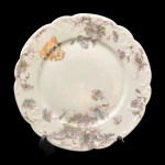 Prato de porcelana francesa, pertencente ao Serviço de Carlos Norberto Egydio de Souza Aranha (1855 -1945), filho do Barão de Itapura. Fundo de superfície branca com decoração floral. Iniciais entrelaçadas. 24 cm. Jurista, fazendeiro e Cavaleiro Fidalgo da Casa Imperial.