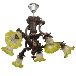 Lustre para seis lâmpadas, em formato de buquê reverso, com bobeches em vidro acidado e bordas onduladas, representando flores. Corpo em cornucópia central, fundida em bronze, com leve torção. Sustentação em hastes com curva e contracurva. 60 x 75 cm.
