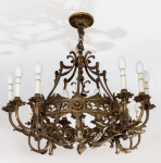 Lustre para doze velas, possivelmente francês, em bronze dourado. Coroa central vazada com estilizações florais, sustentando braços recurvos e encimada por hastes reunidas ao topo com pequeno arremate. Séc. XIX.  81 x 90 cm.