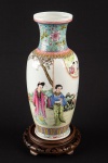 Vaso de porcelana chinesa apresentando fundo de superfície branca. Bojo com reservas com personagens em cena de jardim. 29 x 12 x 8,5 cm. Acompanha base de madeira.