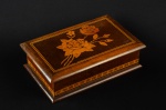 Caixa de madeira de forma retangular. Apresenta decoração floral no tampo e frisos em marqueterie de madeira clara. 8 x 28.5 x 18 cm.
