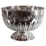 Bowl com pé, de formato globular, em prata inglesa repuxada e cinzelada, ornamentado com gomos encimados por guirlanda florida. Base circular de mesmo estilo. Contrastes de Londres de 1903 e marca de prateiro.11.5 x 16 cm. Peso 319 gramas.