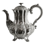 Bule para café em prata inglesa repuxada e cinzelada, ornamentado por reservas e folhagens. Bojo de formato balaústre, lavrado em largos gomos, com alça lateral em S e bico recurvo. Tampa abobadada e base com pés recortados. Contrastes da cidade de Londres de 1833 e marca do prateiro Charles Gordon. 22 x 24 cm. Peso 844 gramas.