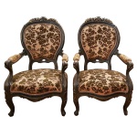 Par de poltronas francesas estilo Louis XV, em madeira patinada esculpida com frisos lisos. Encostos ovalados encimados por composições florais douradas. Braços recurvos apoiados em assentos abaulados. Pernas curvilíneas rematadas por pequenas sapatas. Forração em tecido floral. 100 x 61 65 cm.