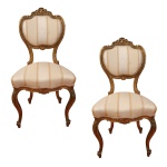 Par de cadeiras estilo francês. Espaldar de forma recortada encimada por florão. Pés curvilíneos. Estofadas de tecido. Séc. XX. 91.5 x 46 x 40 cm.
