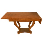 Mesa Biedermeier em radica clara, com tampo retangular liso ladeado por abas reclináveis. Saia lisa apoiada em pernas recurvadas em S, sustentadas por pequeno plateau recortado e pés de bolacha. 76 x 150 x 65 cm (aberta) / 76 x 110 x 65 cm (fechada)