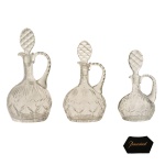 BACCARAT  Raríssimo conjunto de três licoreiros idênticos, em cristal francês da Maison Baccarat, translucido e lapidado. França. Década de 30. 30 x 16 cm; 28 x 15 cm; 23 x 13 cm.