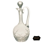 BACCARAT  Licoreiro em cristal francês da Maison Baccarat, translucido. Bojo com decoração em geométricos. Tampa facetada e alça curva. França. Década de 30. 30 cm.