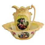 Jarro e bacia de porcelana inglesa, decorado nas cores amarelo e ouro com reservas em representação de figuras femininas em jardim e reservas florais. No fundo as inscrições: Made in England. Séc. XX. 15 x 49 cm.