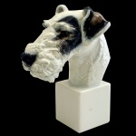 Estatueta na forma de busto de cachorro em porcelana policromada alemã. No fundo marca da manufatura Rosenthal. Germany  Hunstabteilung. Selb Handgemalt. Década de 40. 20 cm.