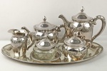 PRATA 90 - WOLFF (WILHELM WOLFF KG METALLWARENFABRIK, PFORZHEIM) - Excepcional Serviço de Chá e Café, executado em metal espessurado a prata, decorado com guirlandas florais, composto de uma Bandeja Oval (45 cm X 28 cm), Bule de Café com tampa retrátil (20 cm X 9 cm), uma Chaleira com tampa retrátil (16 cm X 12 cm), um Açucareiro (12 cm X 10 cm), uma Manteigueira (10 cm X 13 cm) e uma Cremeira (11 cm X 6 cm). EM EXCELENTE ESTADO DE CONSERVAÇÃO. ccc