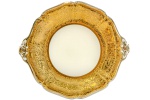 MAUÁ - ANOS 60 - Elegante Prato de Bolo, em fina porcelana toda em ouro com relevos e detalhes em prata, com pegas laterais, fundo na tonalidade marfim; marca da manufatura na base. Dimensões: 30,5 cm X 27 cm (Comp. entre pegas./Diâm.). xxv