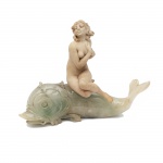 Belíssima e rara escultura representando nu feminino em mármore sobre golfinho executado em jade. Europa, Séc. XIX. 31 x 38 cm.