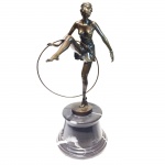 Escultura em bronze no estilo Art Deco. Base em mármore representando dama com bambolê. 34,5 sem a base e 47 cm com a base.