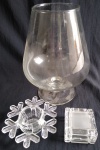 Lote composto de 3 peças em vidro translúcido sendo: Vaso taça, castiçal e caixa (Obs. Apresenta bicados na caixa) peça maior, aprox. 26 x 16 cm de diam 