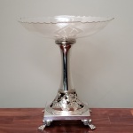Fruteira de metal espessurado a prata, com prato de cristal translúcido e lapidado (original), da manufatura WMF, Alemanha c. 1900. Medidas aproximadas: 26 cm x 30 cm de altura.