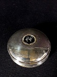 caixa redonda em prata de lei com cristal monogramado incrustado no centro  medindo 4A x 8 de diâmetro.