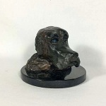 cabeça de cão esculpida em bronze sobre base de granito preto assinada na base tendo 15A x 19 de diâmetro.