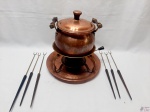 Panela de fondue com rechaud em cobre e 6 espetos com pega em madeira. Medindo a panela 19,5cm alça alça x 12,5cm de altura sem tampa.