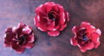 Lote com três peças para decoração, três rosas vermelhas em metal dobrado pintado com tinta automotiva, uma com leve oxidação no metal.