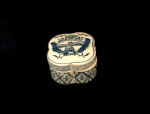 Arte Contemporânea.                                                                                           Pequena caixa em porcelana, Chinesa.                                                                                Azul índigo decorada com cenas fênix.                                                                      Med. Alt. 04,5 cm.                                                                                                                  Larg. 07 cm.