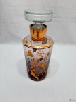 Garrafa, licoreira em cristal lilás com pintura ouro. Medindo 25cm de altura. A tampa possui trincados internos na parte interior, nada visível quando fechado.
